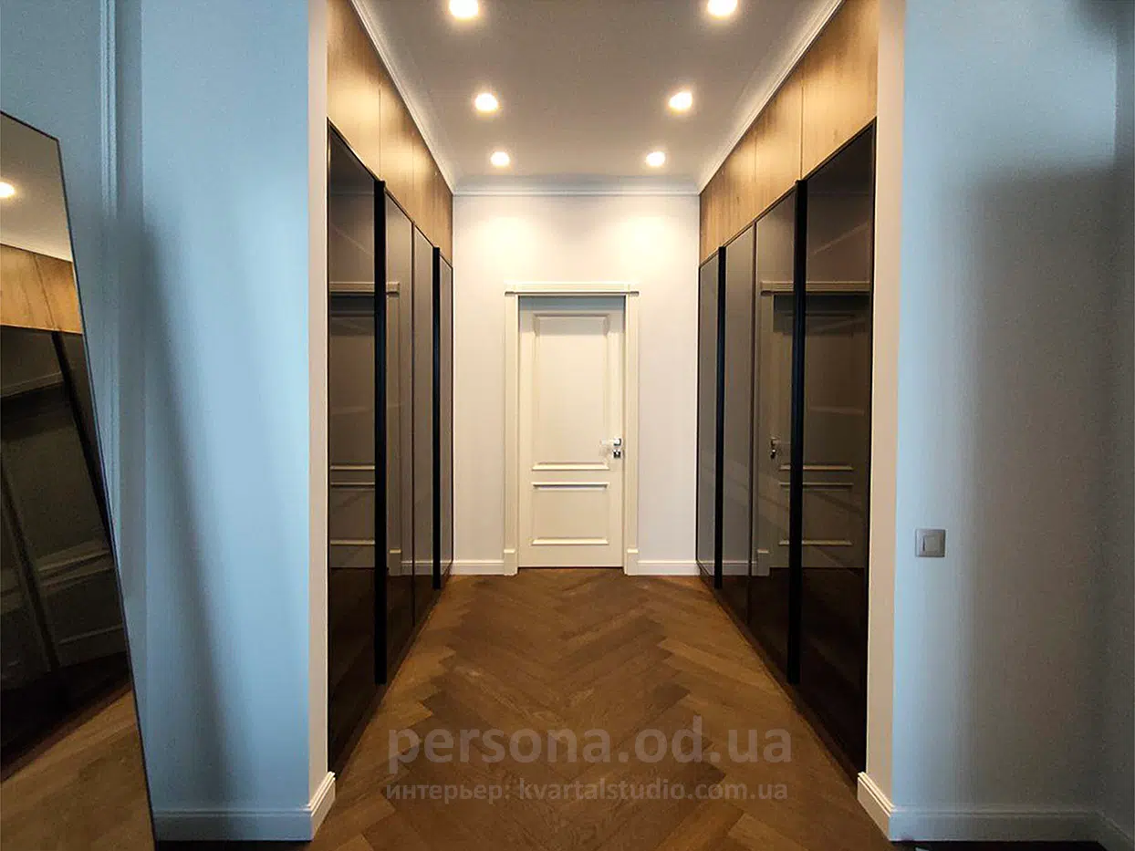 Glass-fronted wardrobes built into a niche